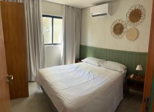 een slaapkamer met een wit bed en een raam bij Casa Artur - Milagres in São Miguel dos Milagres