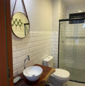 een badkamer met een wastafel, een toilet en een spiegel bij Casa Artur - Milagres in São Miguel dos Milagres