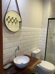 een badkamer met een wastafel en een spiegel en een toilet bij Casa Artur - Milagres in São Miguel dos Milagres +17 foto's