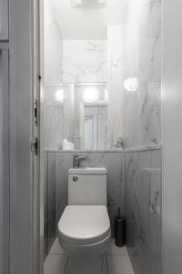 a white bathroom with a toilet and a mirror at The Savers Hotel by PLI in London +190 photos