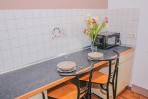 a kitchen with two chairs and a table with a microwave at GMA Apartment B12 in Lahr +4 photos