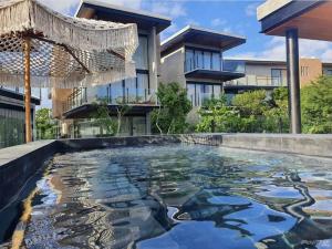 a swimming pool in front of a house at Nook Tulum in Tulum