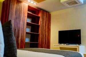 a bedroom with a tv and a bed and a tvicterictericter at Nook Tulum in Tulum