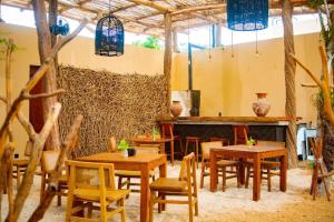 a restaurant with wooden tables and chairs in a room at Nook Tulum in Tulum