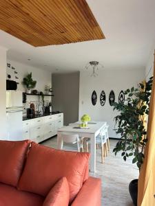 a living room with a couch and a white table at Casa del Árbol in Monte Hermoso