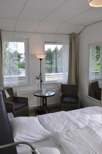 1 dormitorio con 1 cama, 2 sillas y mesa en B&B Het Witte Huis, en Almere