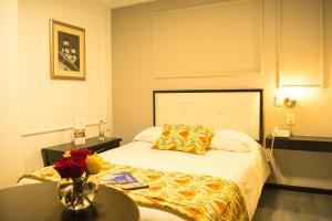 a hotel room with a bed and a table at Hotel Italia - Tranvia Directo Centro & Aeropuerto - Negocios, Familias & Turistas in Cuenca