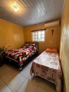 Pântano GrandeにあるHospedagem Familiarのベッドが2つあり、窓がある部屋