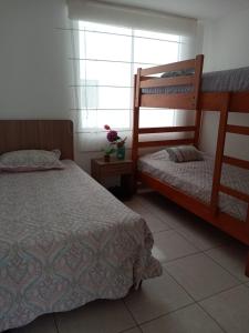 a bedroom with two bunk beds and a window at Departamento de playa in Asia