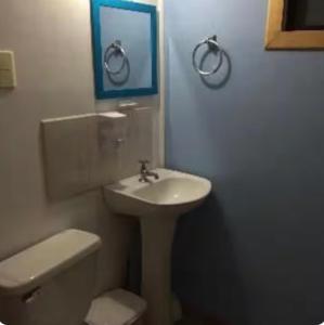 a white bathroom with a sink and a toilet at Cabaña Venti in Bahia Inglesa