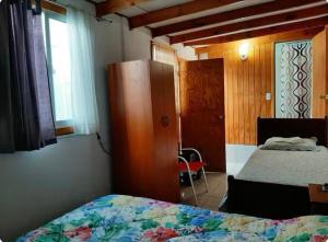 a bedroom with two beds and a cabinet and a window at Cabaña Venti in Bahia Inglesa