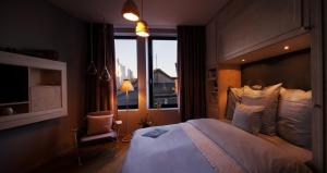 a bedroom with a large bed and a window at Libertine Lindenberg in Frankfurt/Main