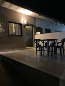 ein Tisch und Stühle auf einer Terrasse bei Nacht in der Unterkunft Casa em Caraguatatuba 2 in Caraguatatuba