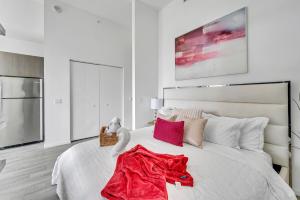 a bedroom with a white bed with a red blanket on it at City Views Studio Downtown Miami in Miami