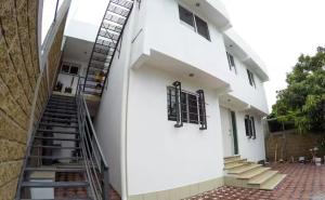 ein weißes Gebäude mit einer Treppe davor in der Unterkunft Edificio Rosedal 2 in Oaxtepec