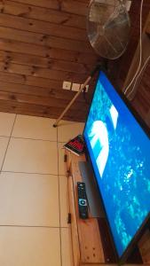 a laptop computer sitting on a table with two remote controls at LES HAUTS DE L'ANSE in Bouillante