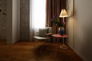 a room with a vase of flowers on a table and a chair at Libertine Lindenberg in Frankfurt/Main
