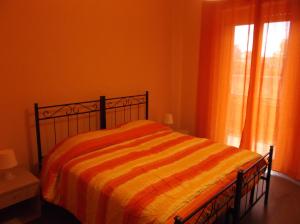 シラクーサにあるVilla Lucia Isolaのベッドルーム1室(オレンジ色の毛布付きのベッド1台付)