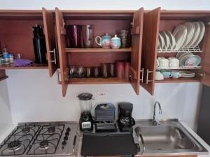 a kitchen with a sink and a stove and cabinets at Apartamento Confort - Planta Alta in Arboletes