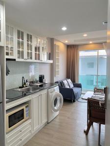 cocina con lavadora y sala de estar. en Lucky Lucky Chill, en Chonburi