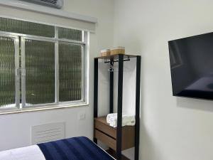 a bedroom with a mirror and a tv and a bed at Studio Completo com Vista no Catete in Rio de Janeiro