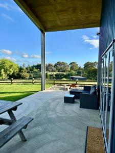 a patio with a couch and a picnic table at Mount Jowett Retreat in Whanganui
