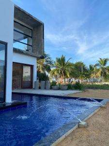 a swimming pool in front of a house at Taipan Casa de Playa in El Puertón