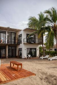 a house on the beach with a bench in front of it at Taipan Casa de Playa in El Puertón