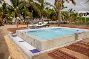 a large stone pool with chairs and palm trees at Taipan Casa de Playa in El Puertón