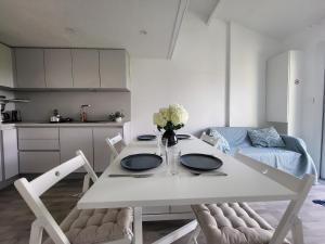 a white dining room table with a vase of flowers on it at Maison rénovée près de la mer avec 2 piscines, parking et animaux acceptés - FR-1-364-174 in Saint-Michel-Chef-Chef