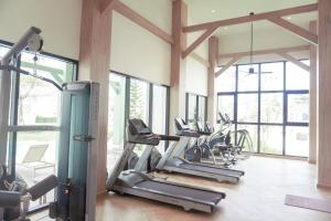 una palestra con diversi tapis roulant e macchine ellittiche di Ruby House a Ban Pa Khlok