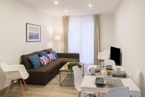 a living room with a couch and a table at Apartamentos Campo Del Príncipe in Granada