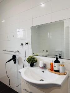 NarweeにあるLovely Modern Family home for your family and friendsの洗面台と鏡のある白いバスルーム