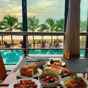 a table with plates of food and a view of a pool at Mana Mui Ne Beach Resort & Spa in Mui Ne