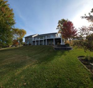 una casa grande en lo alto de un campo de hierba en Charming home on Lake Latoka, en Alexandria