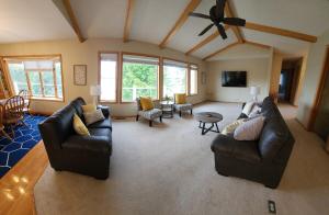 sala de estar con muebles de cuero y ventilador de techo en Charming home on Lake Latoka, en Alexandria