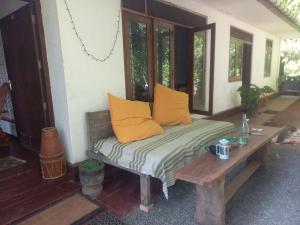 una panchina seduta sul portico di una casa di Oops a Unawatuna