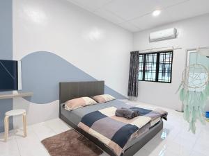 a bedroom with a bed and a desk and a television at Near TC Beach Alor Akar 4R3B fully AC Town area in Kuantan