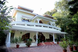 una gran casa blanca con árboles delante de ella en Luxury pool villa kovalam, en Trivandrum