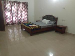 Un dormitorio con una cama y una mesa y una ventana. en Luxury pool villa kovalam, en Trivandrum