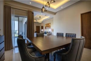 a dining room with a large wooden table and chairs at Blue Forest Residencies in Sri Jayewardenepura Kotte