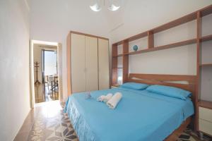 Un dormitorio con una cama azul con toallas. en Marisole House With Sea View, en Santa Cesarea Terme