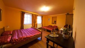 1 Schlafzimmer mit 2 Betten, einem Tisch und einem Fenster in der Unterkunft Penzion Zatisi in Mikulov