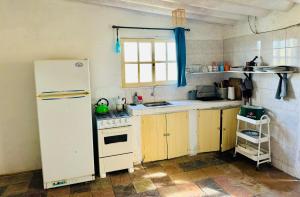 Una cocina con un refrigerador blanco y un fregadero. en Sat Nam, en Cabo Polonio
