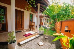 une terrasse couverte d'une maison avec une table et des chaises dans l'établissement Rovenluck Eco Cabana, à Weligama