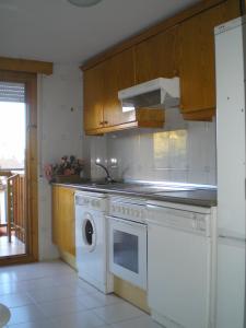 a kitchen with a white stove and a dishwasher at Apartamentos Turisticos Sol y Nieve in Jaca
