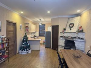 a living room with a christmas tree and a kitchen at Villa Borjomi in Borjomi