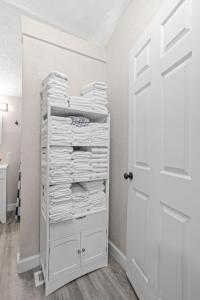 a closet with a white door and a stack of towels at Vibrant Downtown Indy Retreat with Game Room & Patio in Indianapolis +30 photos