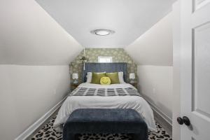 a small bedroom with a bed and a blue ottoman at Vibrant Downtown Indy Retreat with Game Room & Patio in Indianapolis