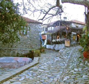 a cobblestone street in front of a stone house at Traditional Guesthouse Archontoula in Palaios Panteleimon